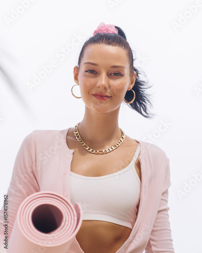 Confident Young Woman Holding Yoga Mat for Beachside Wellness Routine