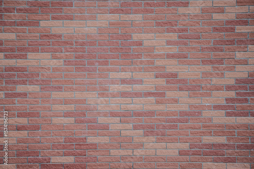 Quadro su tela Simple brick wall surface forms clean geometric texture while soft daylight creates calm urban architectural background with neutral tones