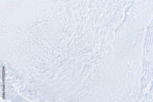 White water with ripples on the surface. Defocus blurred transparent white colored clear calm water surface texture with splashes and bubbles. Water waves with shining pattern texture background.
