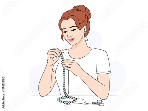 Young woman creating a beautiful pearl necklace with beads and scissors