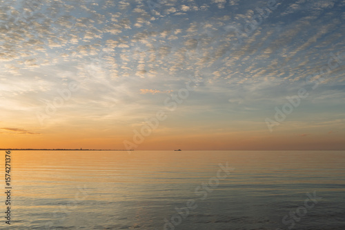 Twilight view across the water from Morwong Beach, with Cleveland Point and a vehicular ferry on the horizon. Coochiemudlo Island, Queensland, Australia 