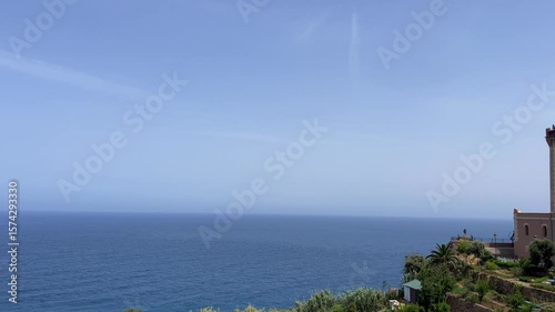 4K video Scenic view of Cap Spartel's lighthouse in front of the ocean surrounded by greenery on a sunny day - Tangier, Morocco
