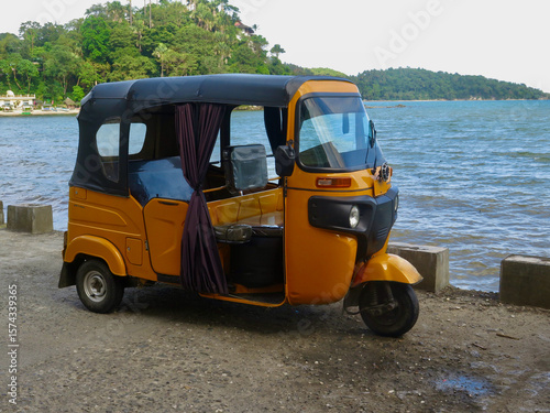 Rickshaw car for transporting people. Motor rickshaw, auto rickshaw, tuk-tuk, mototaxi. Three-wheeled motor scooter.