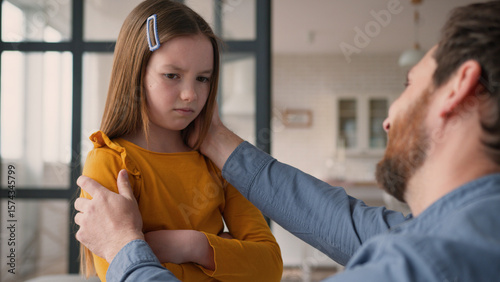Fotografie Stressed Caucasian family argument guilty man father male calming down touch angry little girl offended child daughter kid being stubborn at home
