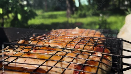 Sausages are grilled over an open fire. Grilled sausages. Frying sausages over coals. Outdoor barbecue sausages. Sausages are grilled over an open fire.