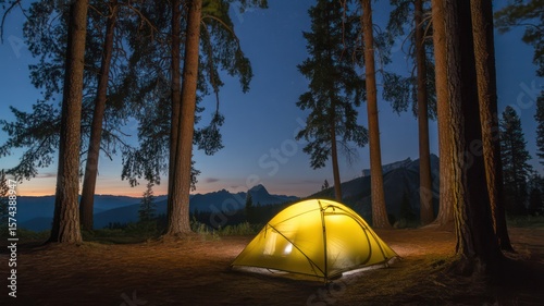 Wallpaper Mural A glowing yellow tent nestled among tall trees at dusk with mountains in the distance camping adventure Torontodigital.ca