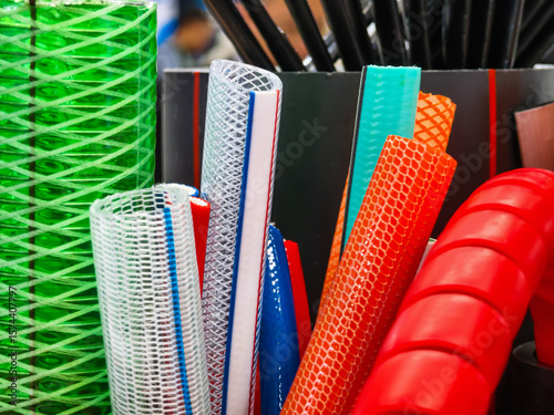 Colorful assortment of plastic tubes and sheets displayed at a market for crafting and DIY projects