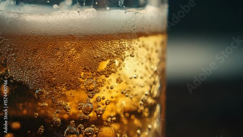 Super slow motion close up of a fresh, foamy cold beer being poured into a glass.