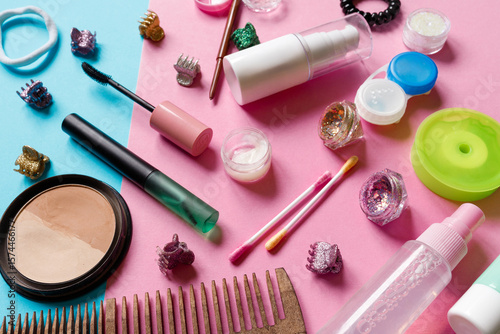 make up accessories on pink and blue background. Women's Cosmetic Bag. mascara, lipstick, cream, glitter, spray, cotton buds, claw clips, bronzer, highlighters, comb