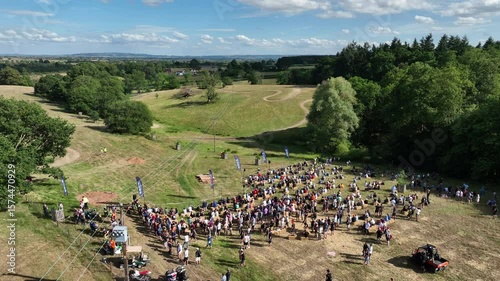 Rural Event Crowd Gathers Beside Twisting Trail in Open Hills