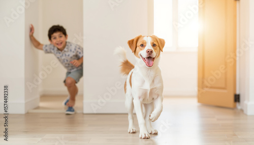 Boy playing with dog while running indoors in bright room  