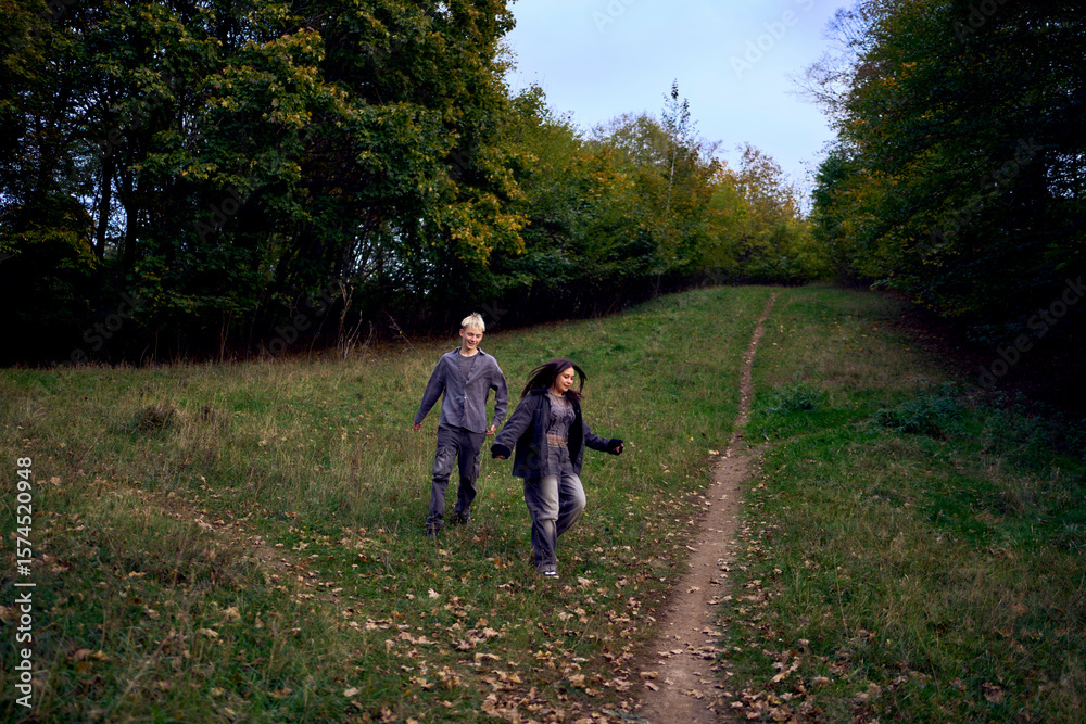 Fototapeta premium two 15-year-old teenagers in love play, hug, spend time together in an autumn park