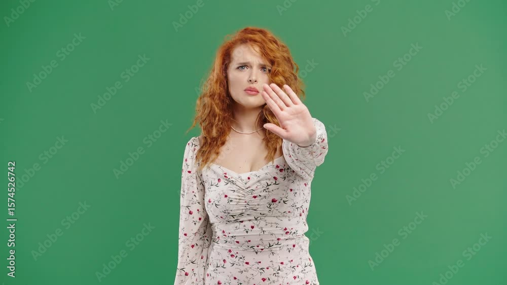 Ginger woman with open palm in stop gesture, clear assertive body language