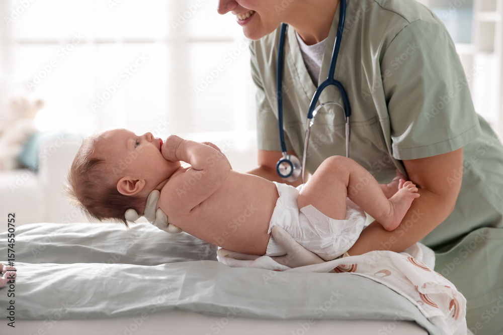 Obraz premium Pediatrician examining baby at table in clinic, closeup