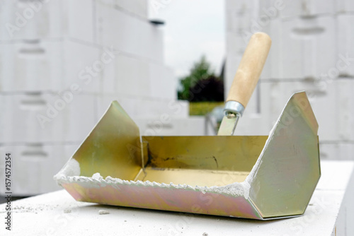 Mason's trowel placed on white hollow bricks