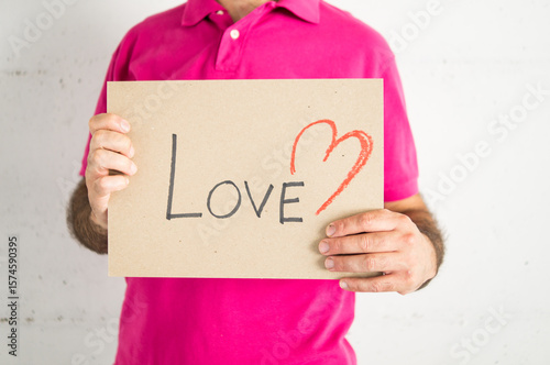 Fotografía Man in a pink t-shirt showing a love sign