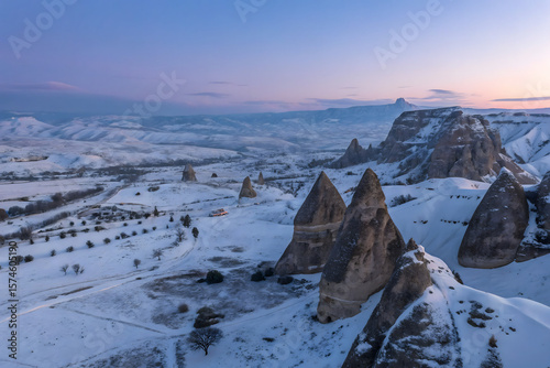 Aerial view of rough rock formations covered with white snow against cloudless evening sky