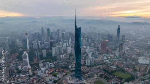 Aerial view time lapse 4k video of Kuala Lumpur city center view during dawn overlooking the city skyline in Federal Territory, Malaysia. Tilt up
