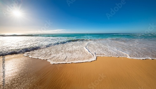 golden sand stretches along a vibrant beach under a clear blue sky waves crash gently on the shore as the scorching sun beats down typical of a summer heatwave
