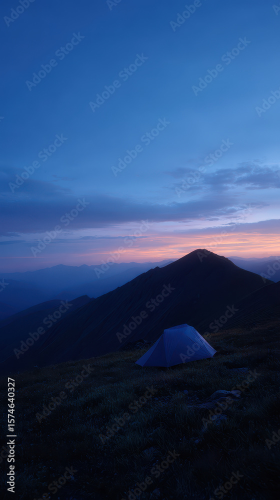 Obraz premium Tent under blue twilight sky with mountain ridge in background
