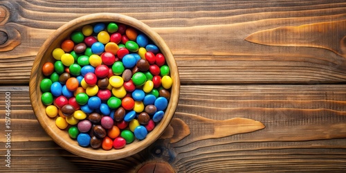 A bowl of colorful M&Ms candies in a vibrant arrangement on a wooden table
