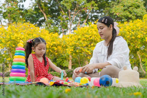 Asian mother and daughter are holidays by doing activities in the park in the park.