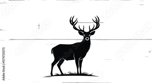 Silhouette of a deer with large antlers standing on grass against wood background