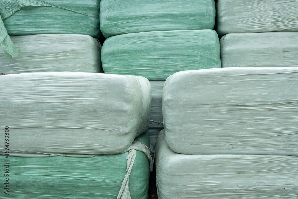 Obraz premium foil-wrapped square bales on farm in storage area