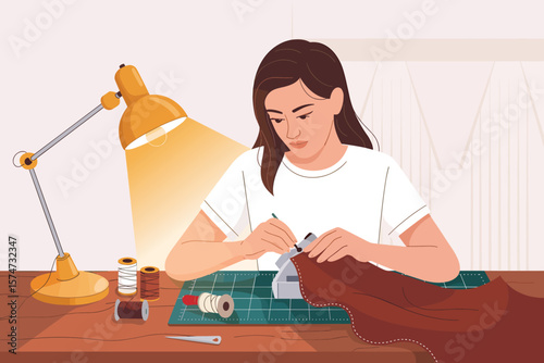 Young woman focused on sewing and crafting under a bright desk lamp