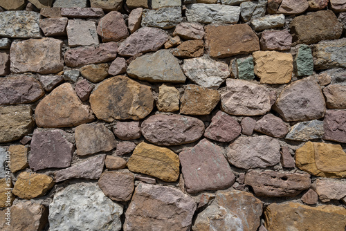 Stone wall. A wall made of large, colorful stones.