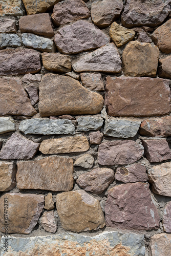Stone wall. A wall made of large, colorful stones.