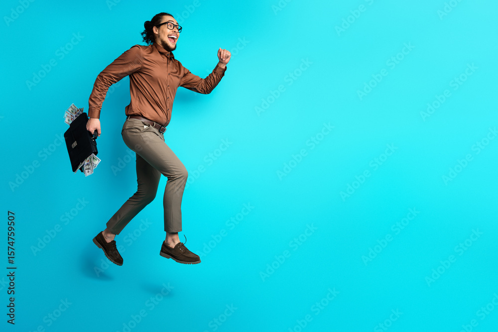 Obraz premium Confident businessman leaps with briefcase against vibrant teal background, embracing success and professionalism