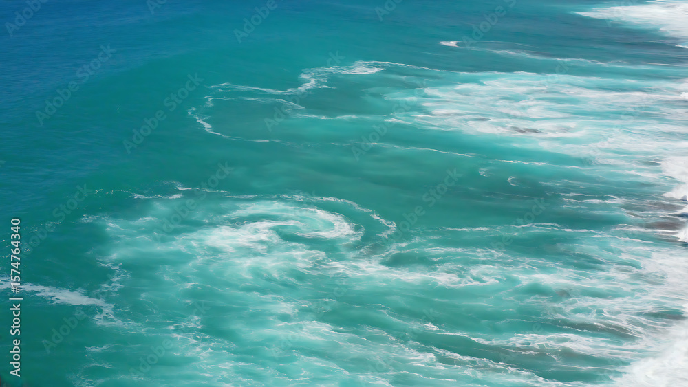 Fototapeta premium Aerial view of the ocean with turquoise water and white foam, showcasing the beauty and power of nature.