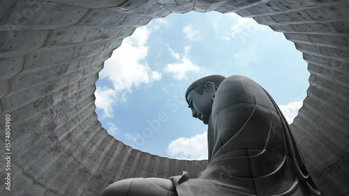 A towering Buddha statue sits beneath an intricate architectural dome, creating a tranquil scene with a captivating sky above. This image emphasizes peace and spirituality, inviting reflection and adm