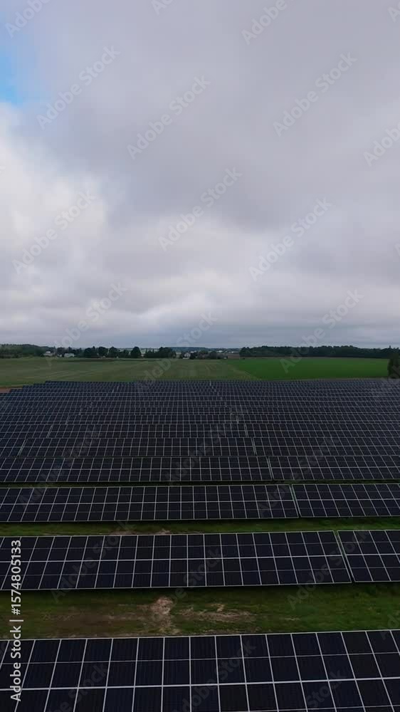 Green field of solar panels harvesting energy rural landscape Clean energy solar panel field in green countryside on cloudy day sustainable power generation Green field of solar panels harvesting energy rural landscape Clean energy solar panel field in green countryside on cloudy day sustainable power generation