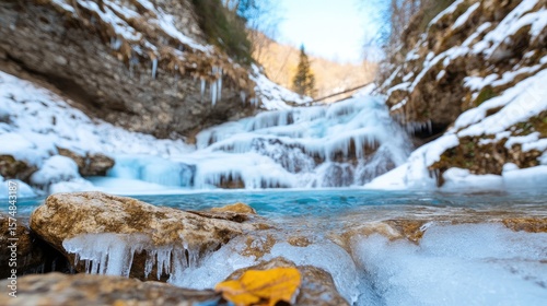 Frozen waterfall cascading down a snowy mountain gorge