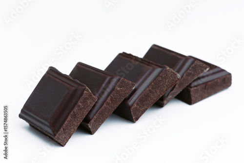 Dark chocolate chunks creating a diagonal line on white background