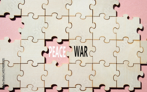 War or Peace symbol. Concept word War or Peace on wooden puzzle. Beautiful pink background. Business and War or Peace concept. Copy space