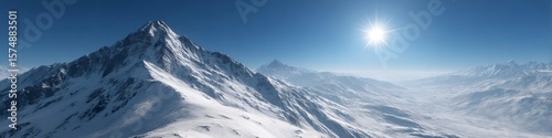 Bright sun shining over snowy mountain range in winter