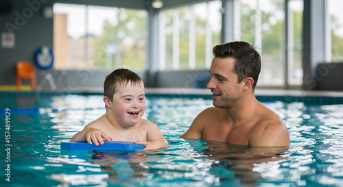 Father and son enjoying swimming together in indoor pool  