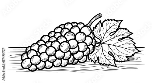Bunch of grapes with leaves resting on wooden surface in black and white
