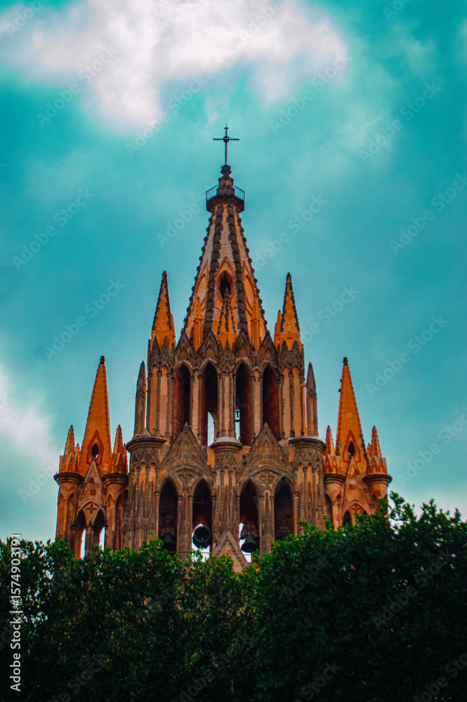 Obraz premium Gothic Revival Church Tower A striking close-up of the iconic pink limestone tower of the Parroquia de San Miguel Arcángel, located in the town of San Miguel de Allende