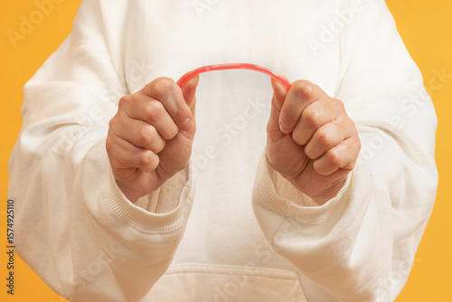 Hands bending a red rubber tube