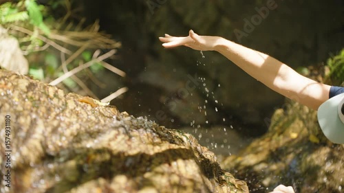 Palm Faces Upward Catching Dripping Stream Water on Jungle Cliff in Slow Motion, Side View, Waterfall Refreshment and Tropical Contact Concept