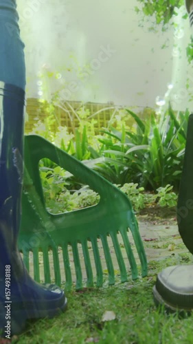 Animation of grass over legs of two people wearing rubber boots working in garden
