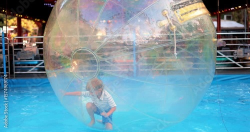 Child Playing Inside Inflatable Water Ball at Amusement Park