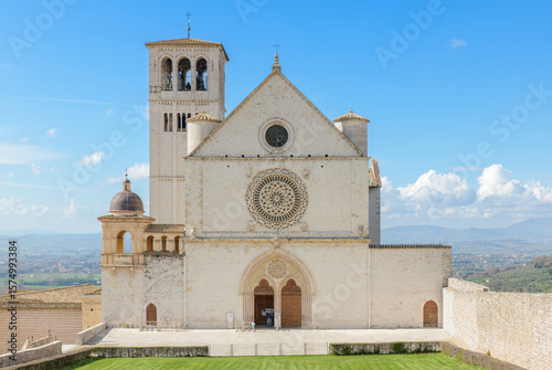 Facade of the Basilica of Saint Francis in Assisi, Italy, featuring a rose window, Gothic portal, and upper church elevation.