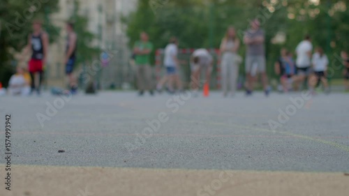 A lively group of enthusiastic basketball players is engaged in an outdoor practice, using colorful cones to enhance teamwork and boost activity levels among all participants
