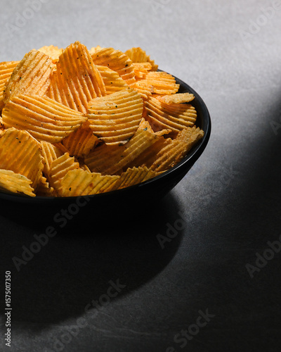 Big bowl of crispy wavy potato chips. Snacks, beer appetizer.