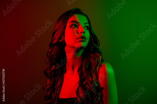 Portrait of attractive young lady model looking empty space isolated multicolor red green neon effect background
